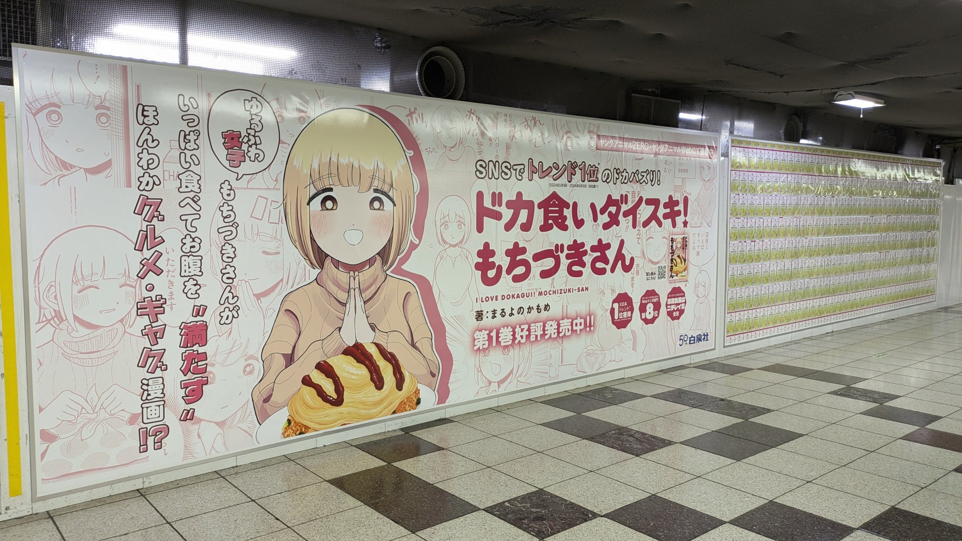 新宿駅に「ドカ食いダイスキ！もちづきさん」のドカ盛り（巨大）ピールオフ広告が登場！コミックス第1巻発売記念